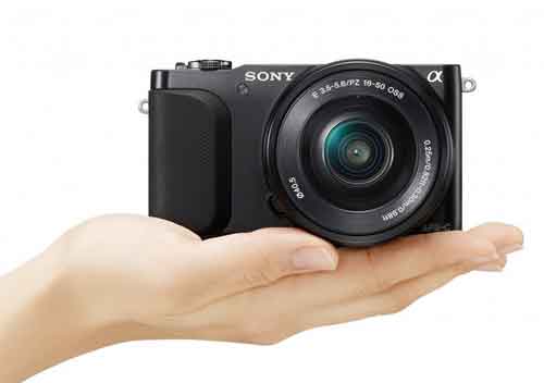 NEX-3N held in the palm of a hand.
