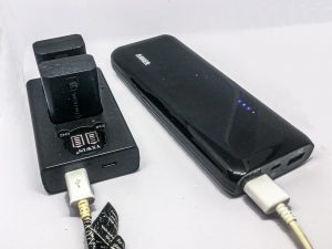 External cell phone battery powering a battery charger